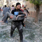 Un hombre traslada a un niño herido en el bombardeo sobre una escuela en Alepo.-Foto: REUTERS/ HOSAM KATAN