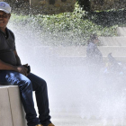 Un hombre con gorra y manga corta sentado junto a una fuente.-VALENTÍN GUISANDE