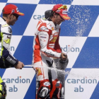Valentino Rossi y Toni Elias rocían a una azafata con champán en el podio de Brno, en el 2009.-REUTERS / PETR JOSEK