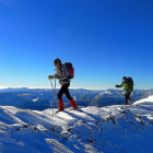 Arriba, dos montañeros progresan por la ancha arista y, a la izquierda, contemplan la vista desde la cumbre de Estorbín de Valverde.-EDUARDO RODRIGO