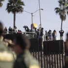 Migrantes en Tijuana, México, miran desde el otro lado del muro durante una visita de la Secretaria de Seguridad, Kirjsten Nielsen.-GREGORY BULL (AP)