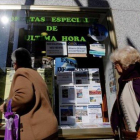 Varias personas miran el escaparate de una agencia de viajes, en Madrid.-AGUSTÍN CATALÁN