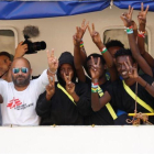 Inmigrantes y miembros de la tripulación del Aquarius celebran su llegada al puerto de La Valeta.-DARRIN ZAMMIT LUPI (REUTERS)