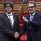 El nuevo presidente de la Generalitat Carles Puigdemont junto a Artur Mas.-AFP / LLUIS GENE