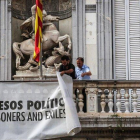 Dos trabajadores de la Generalitat retiran la pancarta que colgaba del Palau, el pasado 27 de septiembre.-ÁNGEL GARCÍA