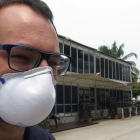 Un trabajador del  Dorna, organizadora del Mundial de motociclismo, con una mascarilla para protegerse de la nube tóxica que flota sobre Malasia.-EMILIO PÉREZ DE ROZAS