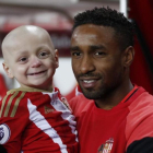 Jermain Defoe, delantero del Sunderland, sostiene en brazos a Bradley Lowery.-REUTERS