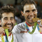 Marc López y Rafael Nadal muerden las medallas de oro.-REUTERS / KEVIN LAMARQUE