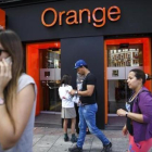 Personas pasan por delante de una tienda de Orange en Madrid.-/ REUTERS / ANDREA COMAS