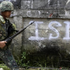 Un soldado filipino patrulla por un vecindario despues de un bombardeo durante los combates contra el EI.-FRANCIS R MALASIG