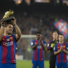 Luis Suárez exhibe el Balón de Oro conquistado de la temporada 2015-16 a la hinchada del Barça en el Camp Nou.-JORDI COTRINA