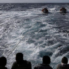 Inmigrantes en la popa del 'Golfo Azzurro', en dirección hacia Sicilia, al día siguiente de ser rescatados por la oenegé Proactiva Open Ams, el 3 de enero.-REUTERS / YANNIS BEHRAKIS