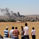 Gente mira el humo de los combates en Kobane desde la frontera turca.-Foto: AFP / STRINGER