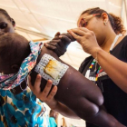 Una enfermera examina a una niña que sufre una infección en la piel, en el hospital de MSF de Malakal (Sudán del Sur), el 15 de junio.-AFP / ALBERT GONZALEZ FARRAN