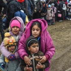 Unos niños sirios esperan junto a otros refugiados para cruzar la frontera entre Macedonia y Serbia.-/ AFP / ARMEND NIMANI