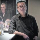 El escritor de ciencia ficción Liu Cixin posa en un céntrico hotel de Barcelona, el lunes. A la derecha, portada de 'El problema de los tres cuerpos' (Nova).-JOAN PUIG