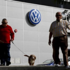 Unos hombres pasean frente a un concesionario de Volkswagen en Sevilla, ayer.-REUTERS