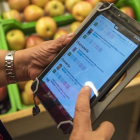 Una persona utiliza una tablet en una frutería. HDS