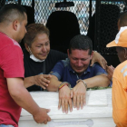 El preso Ricardo Alegría (centro) llora sobre el féretro con los restos de su hija fallecida en Mocoa, el 3 de abril.-AP / FERNANDO VERGARA