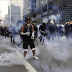 Manifestantes frente a los gases lacrimógenos lanzados por la policía en Hong Kong.-AP / VINCENT YU