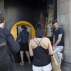 Varias personas esperan para operar en un cajero de una oficina de CaixaBank.-ALBERT BERTRAN