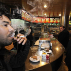 Dos clientes fumaban ayer en un bar en las últimas horas antes de la prohibición. La imagen ya es historia / V. GUISANDE-