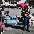 Unos niños buscan sus juguetes en la plaza Victoria de Atenas antes de ser trasladados a las instalaciones olímpicas.-AFP / LOUISA GOULIAMAKI