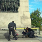 Unos soldados atienden a un compañero herido, ante el monumento de los veteranos de guerra en Ottawa.-
