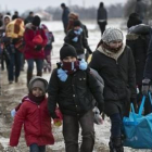 Familias de refugiados, muchos procedentes de Oriente Próximo, llegan a pie a Serbia, para continuar su viaje hacia Europa occidental, este lunes.-AP / VISAR KRYEZIU