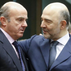 El ministro espanol de Economia, Luis de Guindos, conversa con el comisario europeo de Asuntos Economicos, Pierre Moscovici.-EFE / OLIVIER HOSLET
