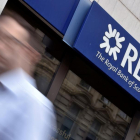 Un hombre camina ante una oficina del banco RBS en Londres.-TOBY MELVILLE / REUTERS