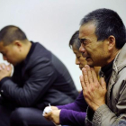 Familiares de los pasajeros del vuelo de Malaysia Airlines rezan, en un hotel de Pekín.-AFP / WANG ZHAO