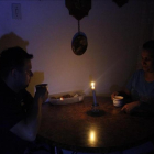 Una pareja toma un café en una establecimiento público a la luz de las velas.-EFE