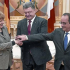 Merkel y Hollande, con el presidente ucraniano, Petró Poroshenko (en el centro), justo antes del inicio de la reunión, ayer, en Kiev.-Foto: REUTERS