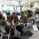 Legionarios tomando unas cervezas junto a sus armas en una terraza.-