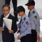 Imagen de archivo del expresidente surcoreano Lee Myung-bak mientras es escoltado por policías en la sala de un tribunal en Seúl.-EFE / JEON HEON-KYUN
