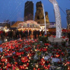 Altar de flores y velas en el mercadillo navideño de Berlín, que ayer reabrió.-AP / MARCUS SCHREIBER