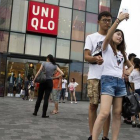 Una pareja de jóvenes se hacen un seli frente a la cadena de ropa Uniqlo, en Pekín.-Foto: AP