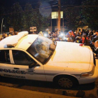 Vecinos de Ferguson golpean un coche de policía, el martes durante las protestas.-Foto: AFP / SCOTT OLSON