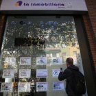 Un joven toma nota de una de las ofertas de pisos disponibles en alquiler en una agencia de Barcelona, esta semana.-ELISENDA PONS