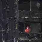 Un bombero inspecciona los restos de la Torre Grenfell, el edificio de apartamentos de 24 plantas en North Kensington, que se incendió el pasado sábado.-EFE