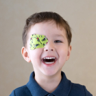 Un niño con un colorido parche para el tratamiento de su visión. HDS
