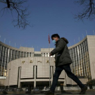 Un hombre pasa por delante de la sede del Banco Central de China, este martes en Pekín.-REUTERS / KIM KYUNG-HOON