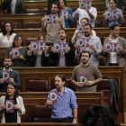 Los diputados de Podemos con octavillas, ayer.-