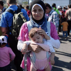 Una refugiada siria con su hija tras llegar a Grecia.-AFP / LOUISA GOULIAMAKI