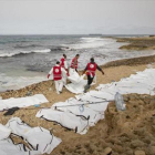 Decenas de cuerpos sin vida de inmigrantes alineados en una playa de Zawiya, ayer.-AFP / AMIN ELAMR
