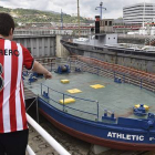 Dos jóvenes observan la gabarra con la que el Athletic Club celebró sus títulos en 1983 y 1984, que no saldrá del Museo Marítimo de Bilbao para festejar la Supercopa de España.-Foto: EFE / MIGUEL TOÑA