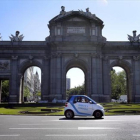Un vehículo de Car2Go circula por la Puerta de Alcalá, en Madrid.-JUAN MANUEL PRATS