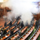 Diputados kosovares evacúan la sala tras el lanzamiento del gas, en la primera sesión parlamentaria del año, en Pristina.-AFP / ARMEND NIMANI