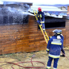 Los bomberos enfrían la cubierta de la planta de biomasa de Ólvega. / ÁLVARO MARTÍNEZ-
